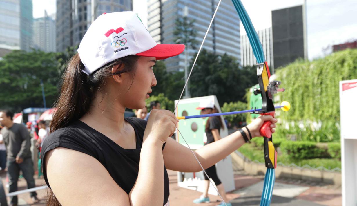 Seorang Model menunjukan aksi memanah pada acara kampanye Indonesia Bisa Emas, Road to Rio 2016 di Senayan, Jakarta, Minggu (20/3/2016). (Bola.com/Nicklas Hanoatubun)