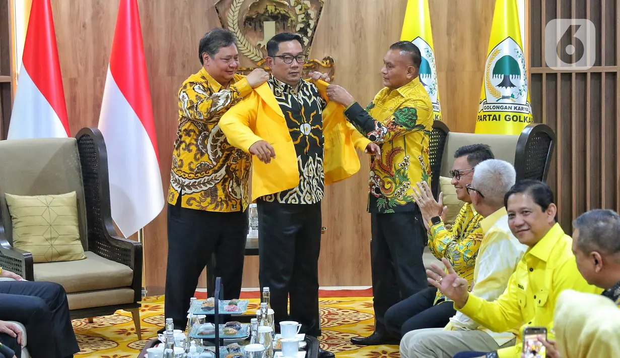 Gubernur Jawa Barat Ridwan Kamil saat memakai jas kuning yang diberikan langsung oleh Ketum Partai Golkar Airlangga Hartarto di DPP Golkar, Jakarta,Rabu (18/1/2023).  Ridwan Kamil resmi bergabung dengan Partai Golkar. (Liputan6.com/Angga Yuniar)