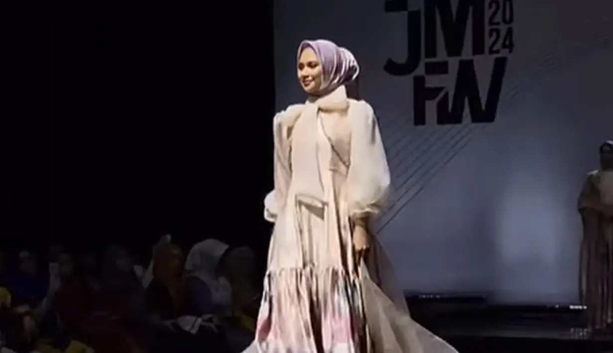 Indah Permatasari melenggang di runway dengan dress flowy yang sangat cantik dan berhijab. [Foto: Instagram/indahpermatas]