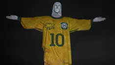 Sebuah gambar yang diproyeksikan ke patung Kristus Sang Penebus memberi penghormatan kepada legenda sepak bola Brasil Pele pada peringatan satu tahun kematiannya, di Gunung Corcovado di Rio de Janeiro, Brasil, Jumat (29/12/2023). (Mauro PIMENTEL / AFP)