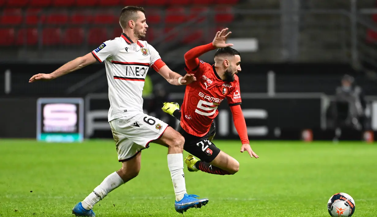 Striker Rennes, Romain Del Castillo (kanan) terjatuh usai perebutan bola dengan gelandang Nice, Morgan Schneiderlin dalam laga lanjutan Liga Prancis 2020/21 pekan ke-27 di Roazhon Park Stadium, Rennes, Jumat, (26/2/2021). Rennes kalah 1-2 dari Nice. (AFP/Damien Meyer)