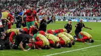 Para pemain Timnas Maroko sujud syukur seusai menyingkirkan Timnas Spanyol untuk lolos ke babak perempat final Piala Dunia 2022. (AP/Martin Meissner).