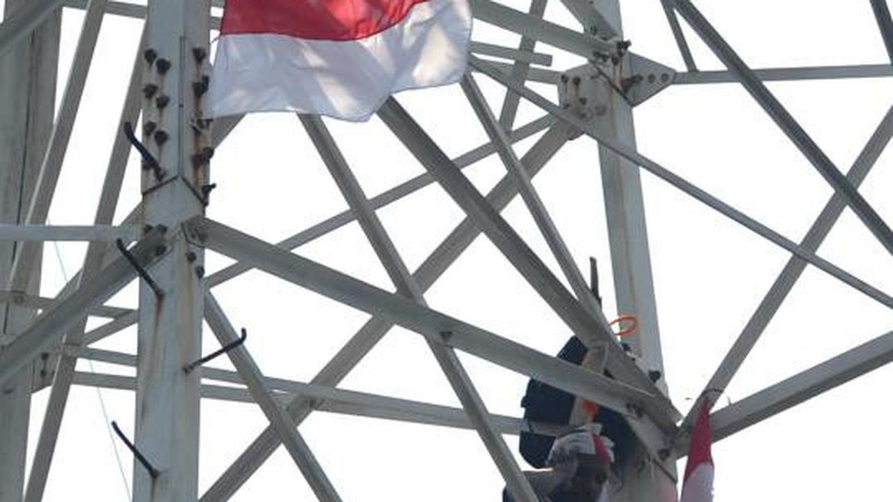 Pria berpakaian pocong di atas tower SUTET