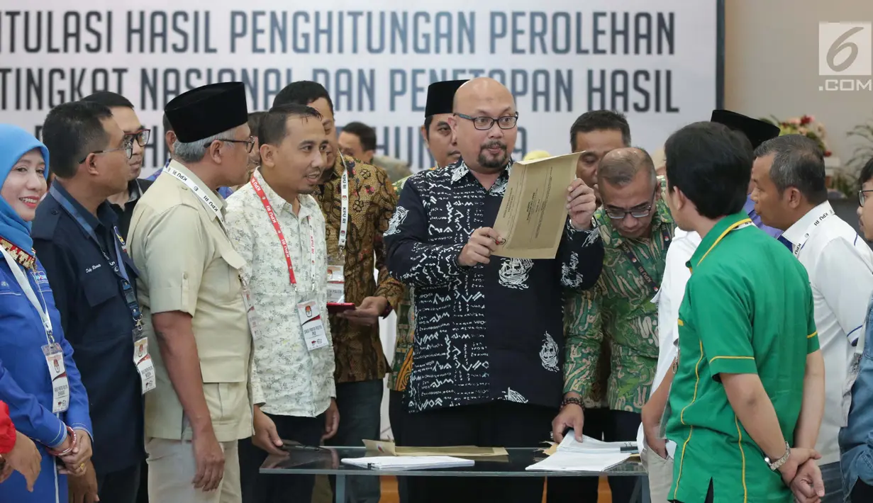 Komisioner KPU RI, Ilham Saputra bersama perwakilan partai politik mengecek keabsahan dokumen rekap penghitungan suara Provinsi Bali saat rapat Rekapitulasi Hasil Penghitungan Perolehan Suara Tingkat Nasional dan Penetapan Hasil Pemilu 2019, Jakarta, (10/5/2019). (Liputan6.com/Helmi Fithriansyah)