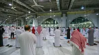 Warga Saudi dan ekspatriat melakukan sholat "Al Fajr" di Masjidil Haram di kota suci Mekkah (18/10/2020). Saudi sebelumnya menutup Masjidil Haram untuk umum selama berbulan-bulan sebagai upaya menghentikan penyebaran virus corona. (AFP/STR)