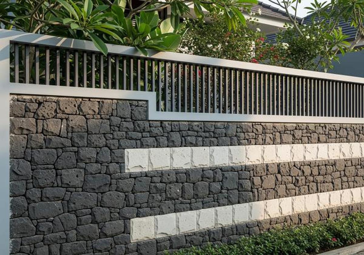 Pagar Semi Tertutup dengan Batu Alam Dominan/Model Pagar Rumah Kombinasi Besi Hollow dan Batu Alam (Sumber: gemini.com)