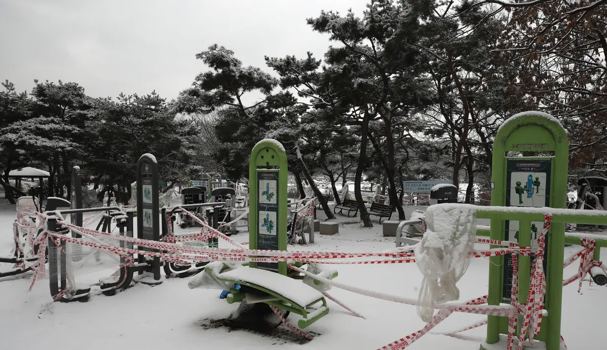Perlengkapan fitness yang tertutup salju direkam untuk tindakan social distancing sebagai pencegahan terhadap virus corona di Goyang, Korea Selatan, Kamis (28/1/2021). (AP/Lee Jin-man)