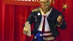 Patung emas mantan presiden Donald Trump yang dipajang pada Konferensi Politik Konservatif (CPAC) di Orlando, Florida, Jumat (26/2/2021). Patung tersebut dalam balutan jas setelan merek dagang Trump dengan celana pendek bertema bendera Amerika, dan sandal jepit. (AP Photo / John Raoux)