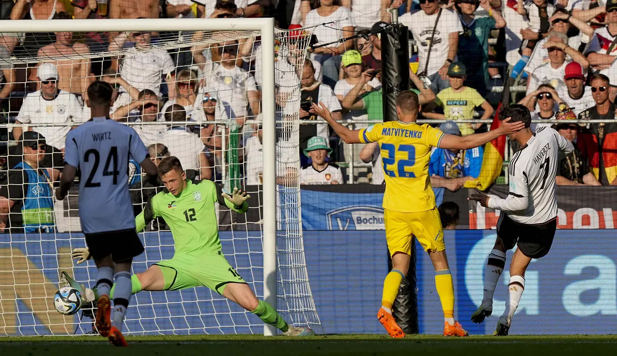 Pemain Timnas Jerman, Kai Havertz (kanan), menendang bola ke gawang Ukraina yang membuahkan gol dalam laga persahabatan internasional FIFA Matchday 2023 yang digelar di Weserstadion, Bremen, Senin (12/6/2023) malam WIB. (AP Photo/Martin Meissner)