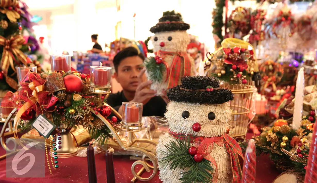 Penjaga stan merapihkan pernak pernik natal di Lippo Mall Kemang, Jakarta, Rabu (16/12). Jelang perayan natal banyak masyarak berburu pernak pernik natal untuk menghiasi perayan natal 2015. (Liputan6.com/Angga Yuniar)