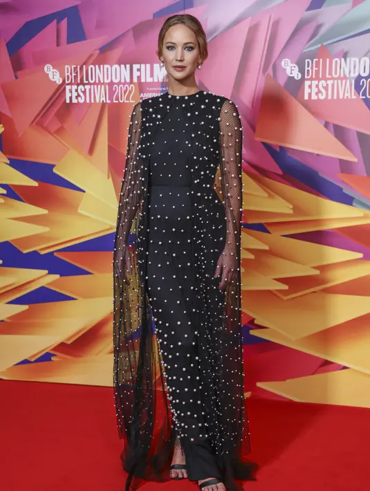 Jennifer Lawrence berpose di karpet merah saat menghadiri pemutaran perdana film ' Causeway' selama Festival Film London 2022 di London, Sabtu, 8 Oktober 2022. Jennifer Lawrence terlihat sangat glamor dalam balutan gaun hitam tipis berhias mutiara. (Photo by Vianney Le Caer/Invision/AP)