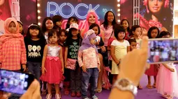 Anak-anak foto bersama wanita cantik berkarakter Barbie di pusat perbelanjaan Lippo Mall Kemang, Jakarta, (19/12). Karakter Barbie yang didatangkan dari Rusia hadir setiap sore saat liburan sekolah dan jelang perayaan Natal. (Liputan6.com/Fery Pradolo)
