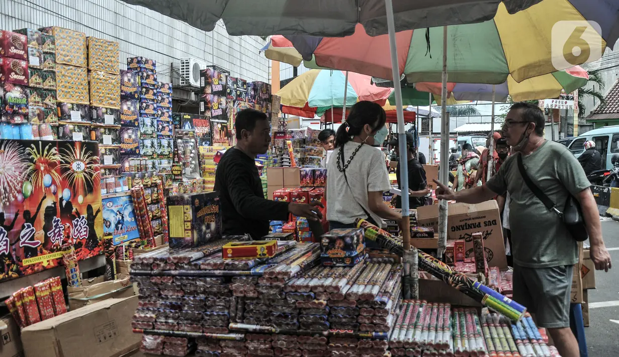 Pembeli melihat berbagai jenis kembang api yang dijual di Pasar Asemka, Jakarta, Selasa (28/12/2021). Pedagang di Pasar Asemka pun mengaku penjualan petasan dan kembang api saat ini mengalami penurunan. (merdeka.com/Iqbal S Nugroho)