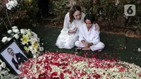 Bunga Citra Lestari atau BCL bersama anaknya Noah Sinclair duduk di samping makam Ashraf Sinclair di San Diego Hills, Karawang, Jawa Barat, Selasa (18/2/2020). Ashraf Sinclair mengembuskan napas terakhir pukul 04.51 WIB pagi tadi. (Liputan6.com/Faizal Fanani)