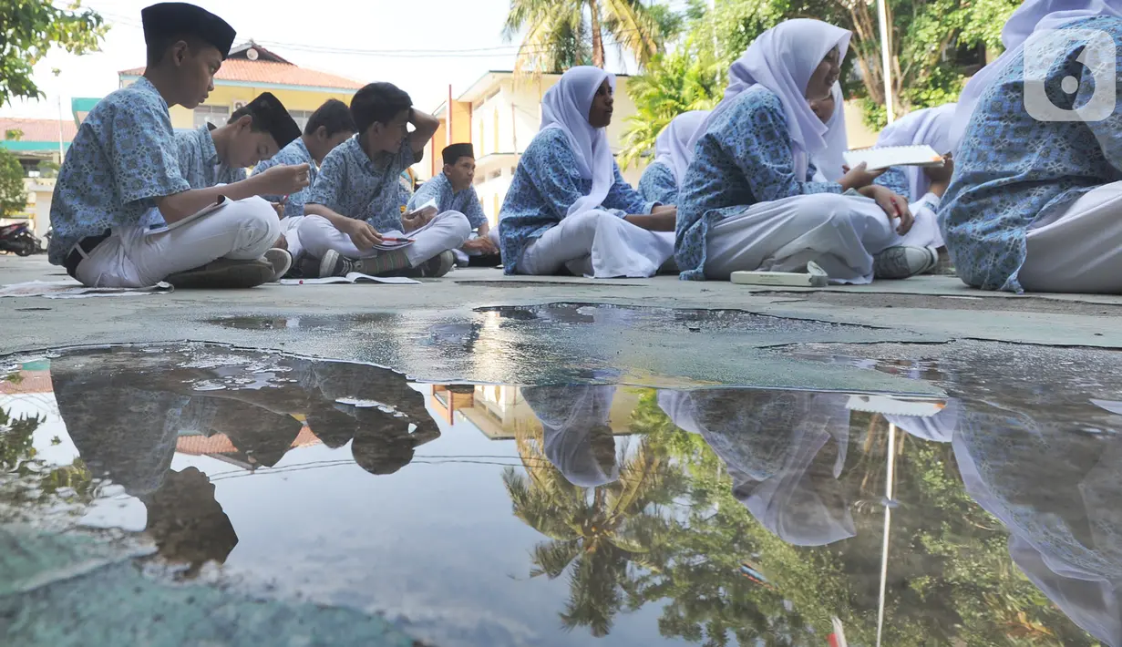 Siswa kelas VIII belajar mata pelajaran Sejarah Kebudayaan di halaman sekolah Mts. Hidayatul Umam di Cinere, Depok, Kamis (7/11/2019). Kegiatan hari belajar di luar kelas yang serentak di seluruh Indonesia ini dilakukan dalam rangka memperingati hari anak internasional. (merdeka.com/Arie Basuki)