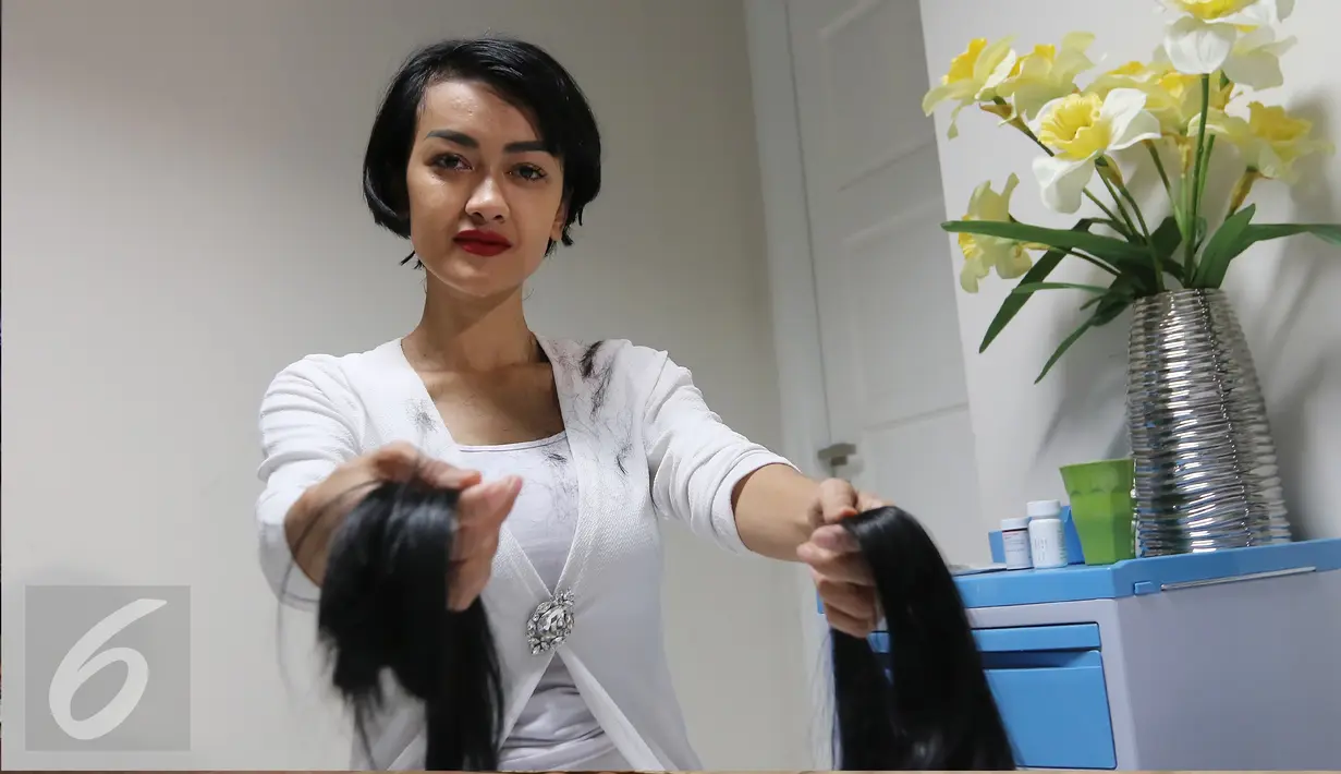 Aktris Julia Perez atau Jupe memotong  rambutnya  dalam syuting film di kediamannya jakarta, Kamis (25/02). Dalam adegan syuting film tersebut Jupe memotong rambutnya sebagai bentuk kepedulian kepada pejuang kanker. (Liputan6.com/Herman Zakharia)