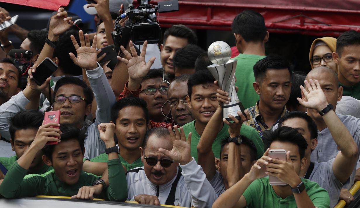Pemain dan ofisial Timnas Indonesia U-22 menaiki bus tingkat saat konvoi menuju Istana Negara Jakarta, Kamis (28/2). Pawai tersebut untuk merayakan keberhasilan skuat Garuda Muda menjuarai Piala AFF U-22 di Kamboja. (Bola.com/M Iqbal Ichsan)