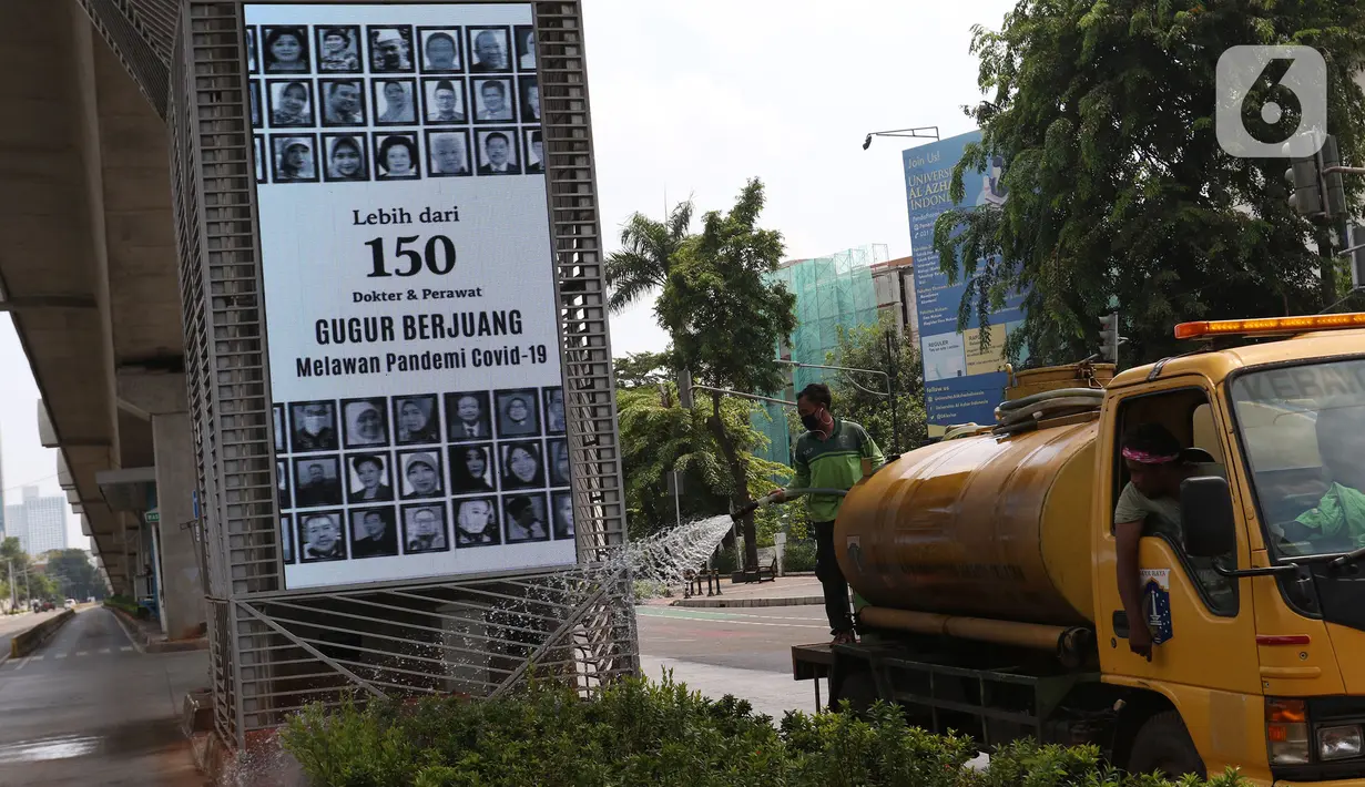Petugas menyiram tanaman dengan latar belakang videotron penghormatan kepada tenaga medis yang gugur akibat Covid-19 di tiang penyangga lintasan MRT, Jalan Sisingamangaraja, Jakarta, Jumat (18/9/2020). Masyarakat diharapkan waspada akan ancaman Covid-19. (Liputan6.com/Herman Zakharia)