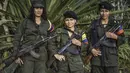 Tiga gerilyawati FARC berpose di kamp Magdalena Medio, Kolombia (15/3/2016). Gerilyawati FARC dikenal lebih sadis terhadap musuh daripada pasukan gerilyawan. (AFP Photo/Luis Acosta)