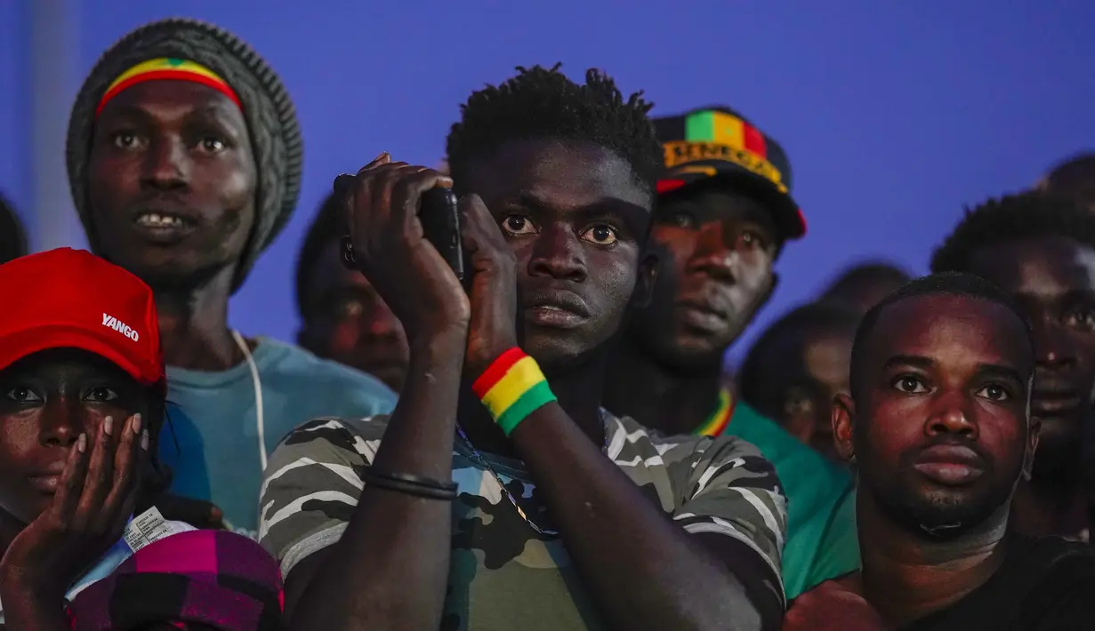 Suporter Senegal menonton pertandingan babak 16 besar Piala Dunia 2022 saat tim kesayangan mereka melawan Inggris di Qatar, lewat layar video yang dipsang di fan zone di Dakar, Senin (5/12/2022) dini hari WIB. Senegal ditaklukkan Inggris dengan skor 0-3. (AP Photo/Leo Correa)