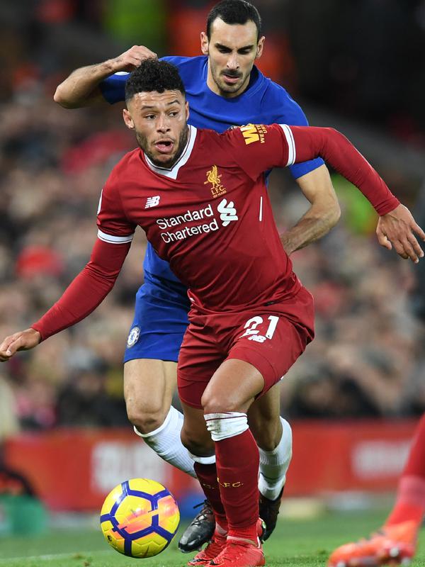 Gelandang Liverpool, Alex Oxlade-Chamberlain membawa bola dari kejaran bek Chelsea, Davide Zappacosta saat bertanding pada lanjutan Liga Inggris di Stadion Anfield, Inggris (25/11). Liverpool bermain imbang 1-1 atas Chelsea. (AFP Photo/Paul Ellis)