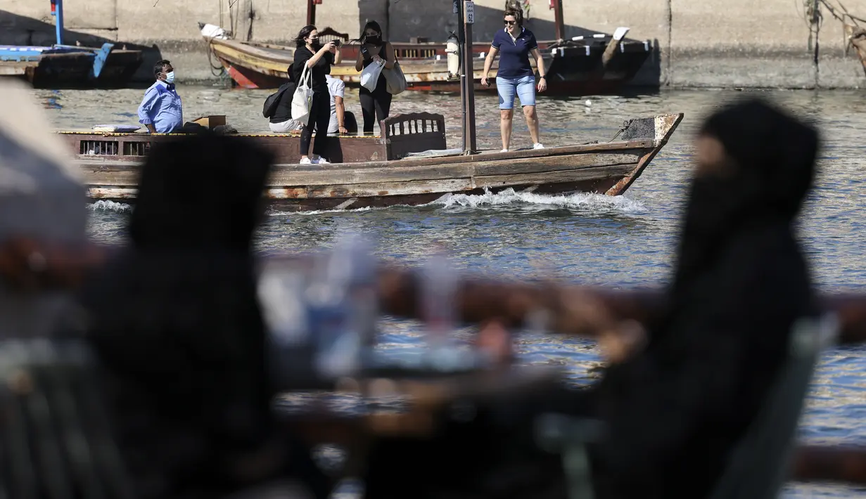 Orang Emirat terlihat sebagai perahu yang membawa turis berlayar di suaka margasatwa Ras Al-Khor dekat kawasan tua kota Teluk Dubai (6/1/2021).  Cagar ini memiliki banyak burung, crustacea, sedikit mamalia dan ikan. (AFP/Karim Sahib)