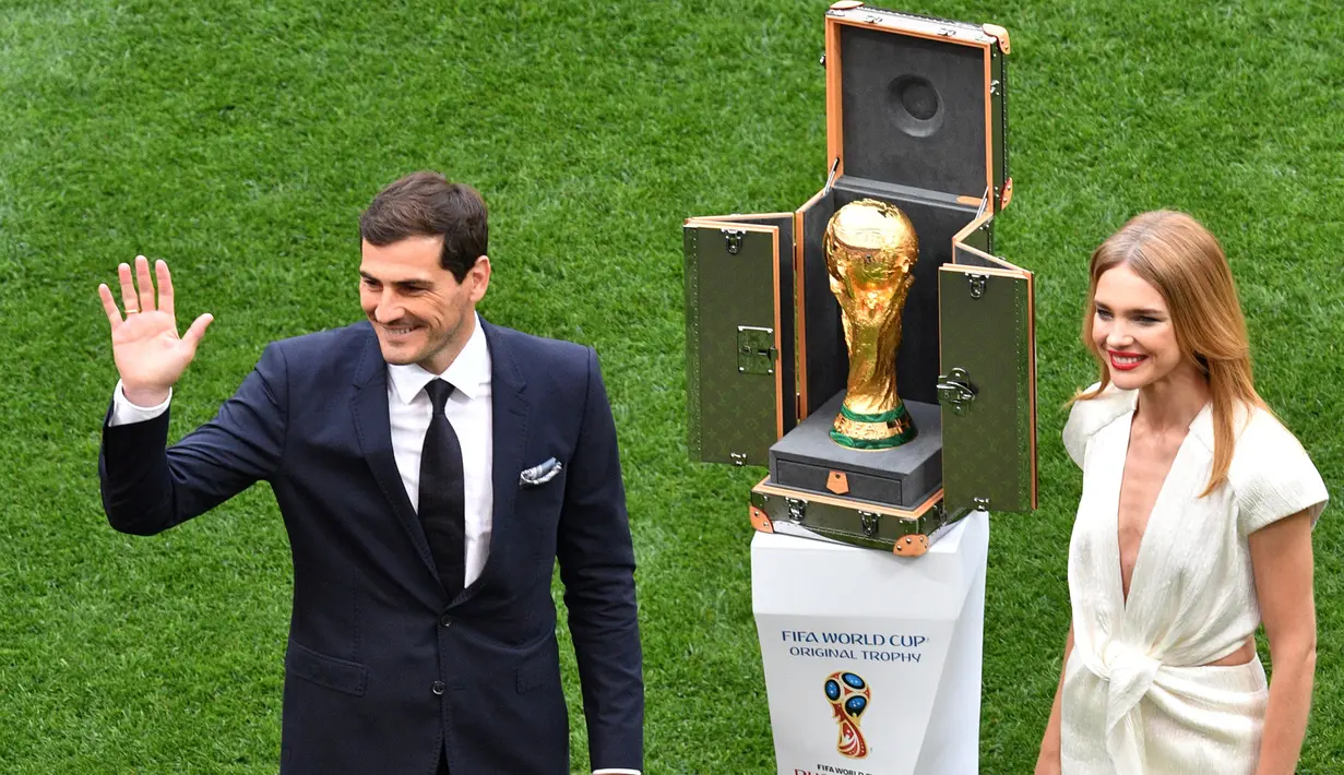 Mantan kiper timnas Spanyol, Iker Casillas dan supermodel Rusia, Natalia Vodianova berdiri di samping trofi Piala Dunia 2018 sebelum laga pembuka di stadion Luzhniki, Kamis (14/6). Trofi disimpan dalam kotak yang didesain Luis Vuitton (AFP/Mladen ANTONOV)
