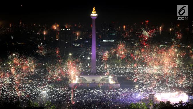 Kembang api menghiasi malam pergantian tahun baru 2018 di kawasan silang Monumen Nasional (Monas), Jakarta, Senin (1/1/2018). Monas menjadi salah satu lokasi pilihan Warga Jakarta untuk merayakan malam pergantian tahun. (Liputan6.com/Johan Tallo)