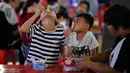 Anak-anak menikmati makanan ringan di sebuah pasar malam di Haikou, ibu kota Provinsi Hainan, China selatan (26/3/2020). Provinsi Kepulauan Hainan di China selatan pada Selasa (24/3) mencatatkan penurunan jumlah kasus penyakit coronavirus baru (COVID-19) yang ada menjadi nol. (Xinhua/Guo Cheng)