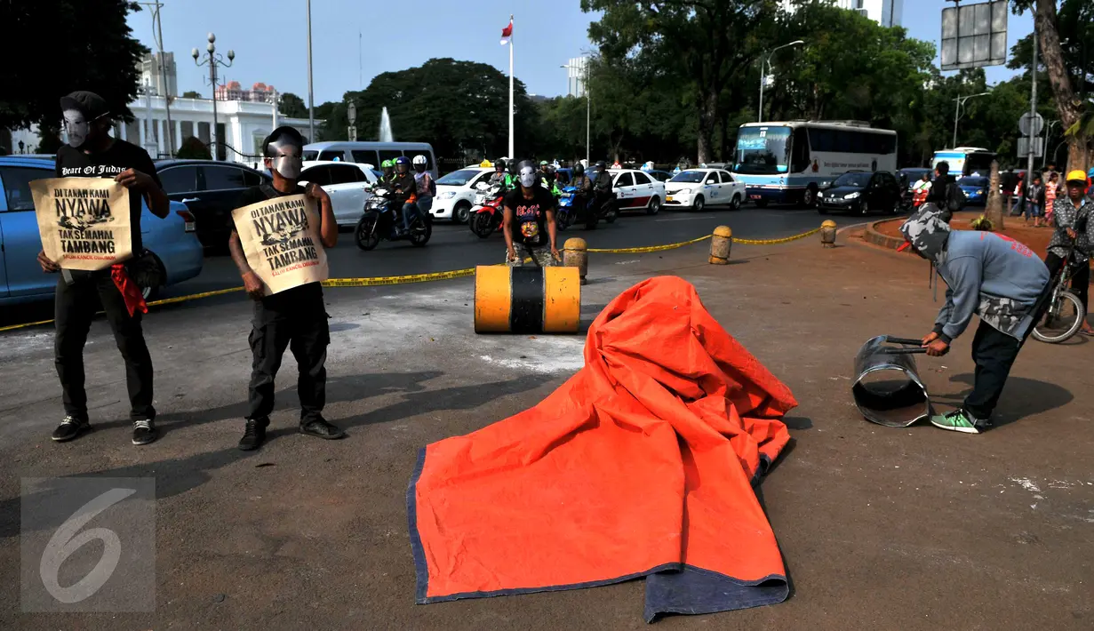 Sekelompok masyarakat yang tergabung dalam gerakan solidaritas untuk Salim Kancil menggelar aksi teaterikal di depan Istana Negara, Jakarta, Kamis (1/10/2015). Mereka menuntut keadilan bagi Salim Kancil dan Tosan. (Liputan6.com/Gempur M Surya)
