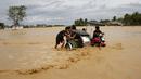 Sejumlah warga mendorong sebuah becak tradisional yang terjebak banjir di Nueva Ecija,  Filipina, Senin (19/10/2015). Badai terjadi pada Minggu pagi waktu setempat. (REUTERS/Erik De Castro)