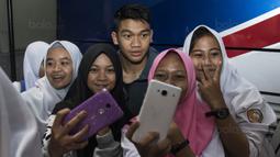 Bek Timnas Indonesia U-19, Samuel Christianson, selfie bersama fans usai latihan di Stadion Wibawa Mukti, Bekasi, Senin (16/10//2017). Kehadiran fans dengan senang hati disambut pemain Timnas U-19. (Bola.com/Vitalis Yogi Trisna)