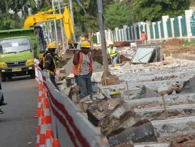 Pekerja melakukan pengerjaan renovasi pedestrian di kawasan Jalan Gerbang Pemuda, Jakarta, Selasa (17/4). Jelang perhelatan Asian Games XVIII, pedestrian di sekitar kawasan Gelora Bung Karno (GBK) terus ditata. (Liputan6.com/Helmi Fithriansyah)
