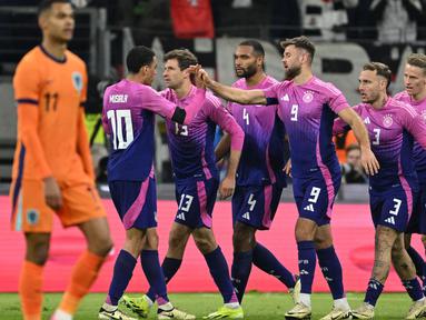 Penyerang Jerman, Niclas Fullkrug (ketiga kanan) merayakan gol bersama dengan rekan setimnya dalam pertandingan sepak bola persahabatan melawa Belanda di Frankfurt, Jerman, pada 26 Maret 2024. (INA FASSBENDER/AFP)