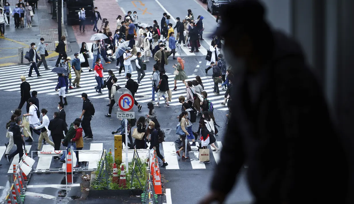 Seorang pria melihat keluar melalui jendela pada awal liburan "Minggu Emas" Jepang di distrik Shibuya, Tokyo (29/4/2021). Periode Golden Week bergantung pada tahunnya, tapi dimulai sekitar 29 April dan berakhir sekitar 5 Mei. (AP Photo/Eugene Hoshiko)