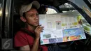 Seorang pengendara memperlihatkan peta mudik 2015, Jakarta, Jumat (26/6/2015). Pembagian peta tersebut diharapkan mampu meningkatkan keselamatan dalam bermudik. (Liputan6.com/Johan Tallo)