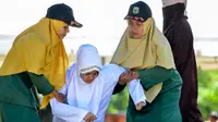Polisi syariah membawa Nur Fadilah (21) usai dihukum cambuk karena mesum di Banda Aceh, Senin (29/10). Ikhtilat adalah perbuatan bermesraan antara laki-laki dan perempuan yang bukan suami istri dengan kerelaan kedua belah pihak. (Chaideer Mahyuddin/AFP)