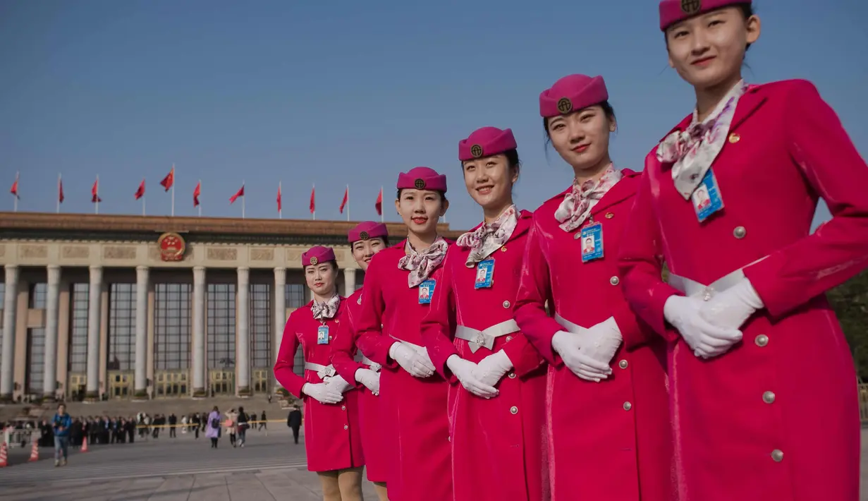 Para pemandu berpose  di lapangan Tiananmen selama sesi penutupan Kongres Partai Komunis ke-19 di Beijing (24/10). Kongres Partai Komunis ke-19 secara resmi mengangkat Xi Jinping sebagai penguasa negara tersebut. (AFP Photo/ Nicolas Asfouri)