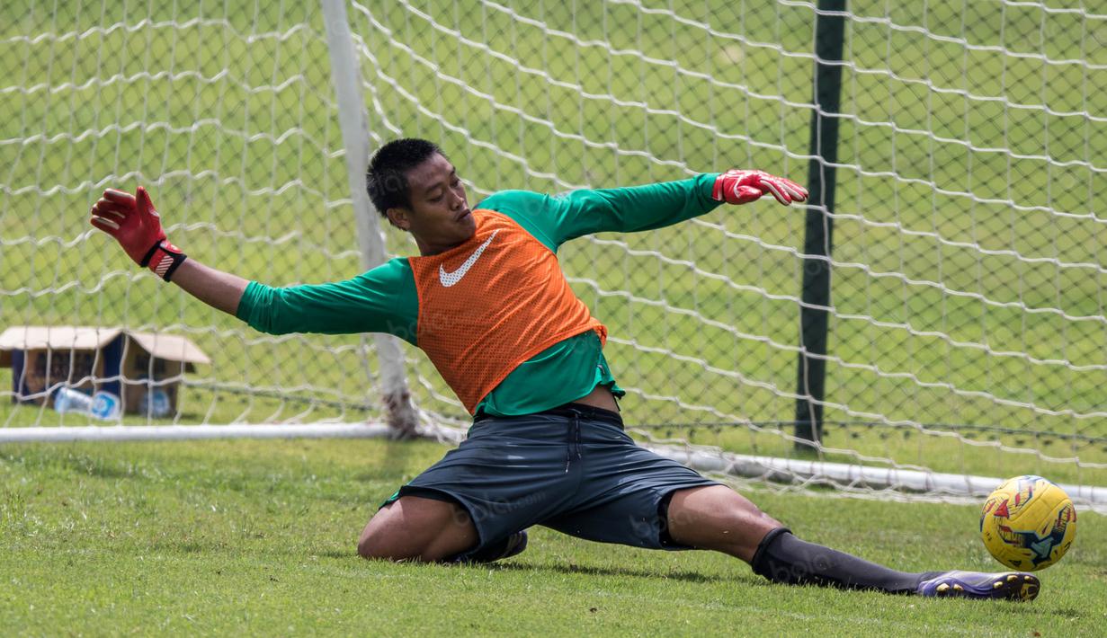 Kiper Timnas Indonesia, Kurnia Meiga, berusaha menghalau bola saat berlatih di Lapangan SPH Karawaci, Banten, Minggu (11/12/2016). (Bola.com/Vitalis Yogi Trisna)