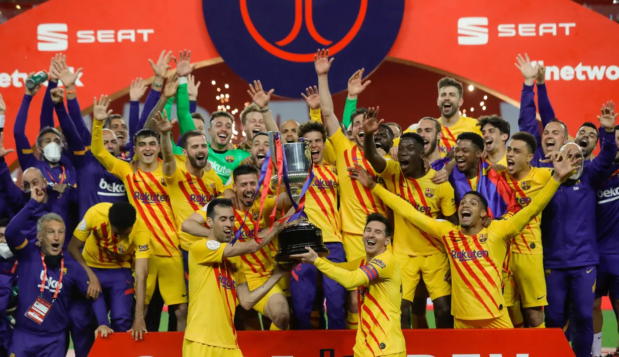 Para pemain Barcelona memegang trofi saat mereka merayakan kemenangan setelah memenangkan final Copa del Rey Spanyol 2021 melawan Athletic Bilbao di stadion La Cartuja di Seville, Spanyol, Minggu (18/4/2021). Barcelona menang atas Athletic Bilbao 4-0.  (HANDOUT / RFEF / AFP)