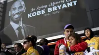 Para fans berduka atas meninggalnya Kobe Bryant di depan La Live seberang Staples Center, kandang Los Angeles (LA) Lakers di Los Angeles, Minggu (26/1/2020). (Keith Birmingham / The Orange County Daftar melalui AP)