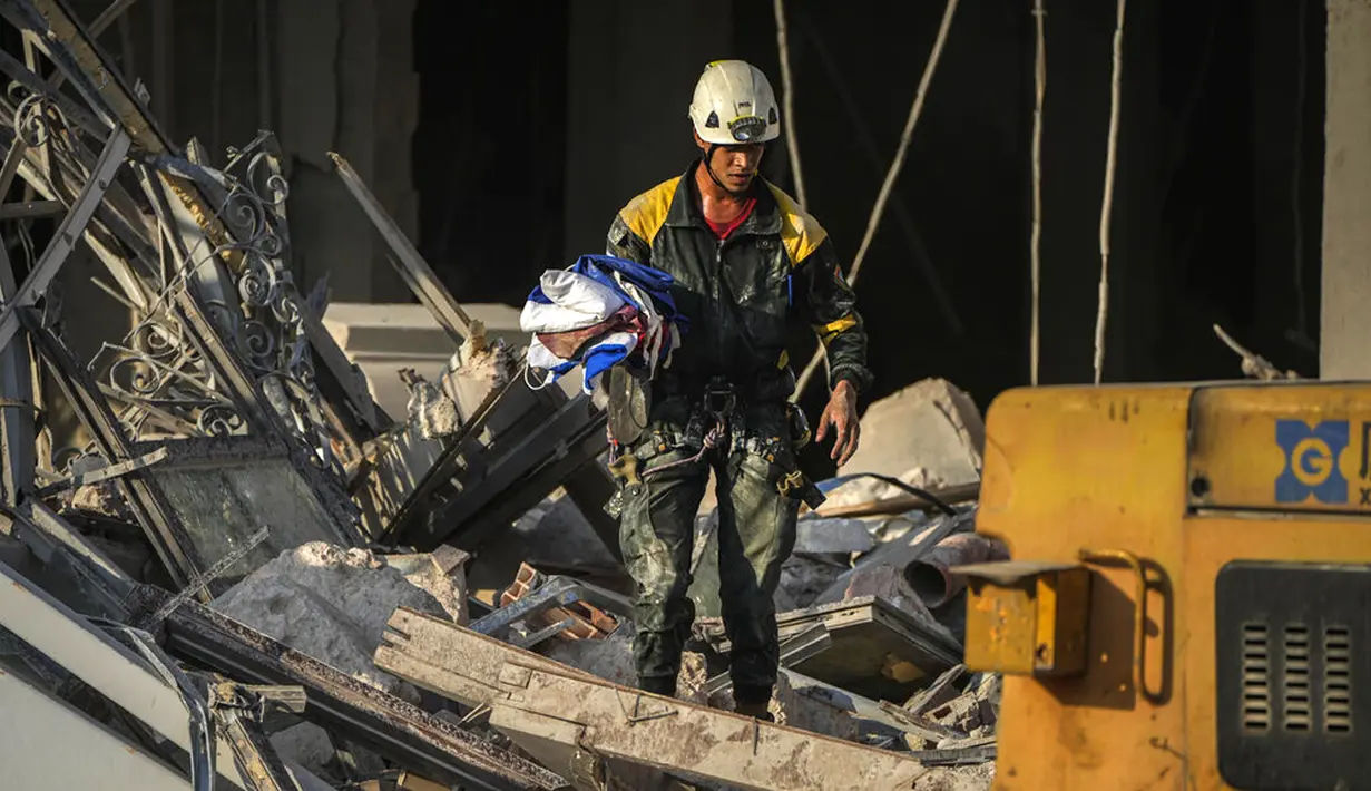 <p>Seorang anggota tim penyelamat menemukan bendera nasional Kuba pada lokasi ledakan mematikan yang menghancurkan Hotel Saratoga di Havana, Kuba, 6 Mei 2022. Ledakan kuat yang diduga disebabkan oleh kebocoran gas alam menewaskan 18 orang dan melukai puluhan orang. (AP Photo/Ramon Espinosa)</p>