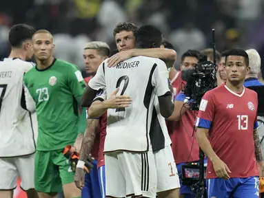 Pemain Jerman, Thomas Mueller (tengah) memberikan pelukan kepada rekannya, Antonio Ruediger setelah gagal lolos ke babak 16 besar saat matchday ketiga Grup E Piala Dunia 2022 melawan Kosta Rika di Al Bayt Stadium, Jumat (02/12/2022). (AP/Hassan Ammar)