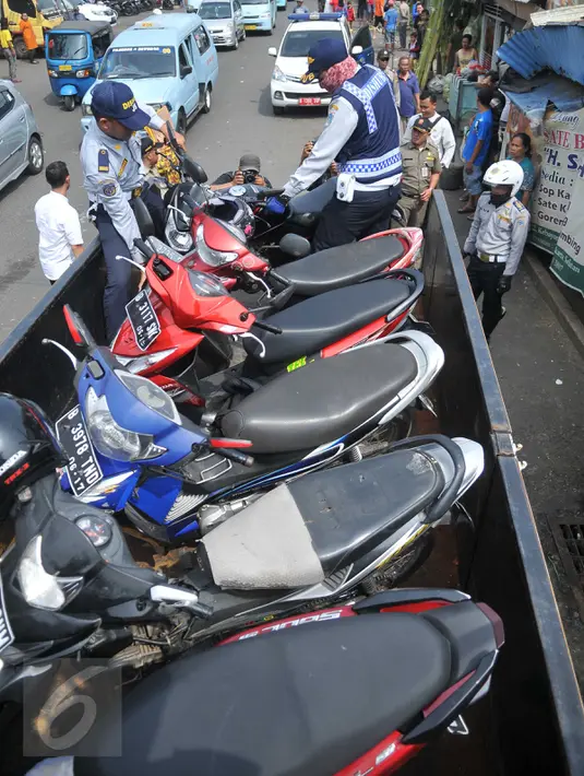 Sejumlah motor yang parkir di bahu jalan kawasan Kebayoran Lama, Jakarta, diangkut petugas, Kamis (12/5). Razia dilakukan untuk menertibkan kawasan itu dan membuat jera pengendara yang memarkir kendaraan bukan pada tempatnya. (Liputan6.com/Gempur M Surya)