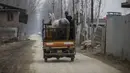 Seorang pria Kashmir mengangkut seekor kuda dengan pengangkut muatan pada hari yang dingin di pinggiran Srinagar, Kashmir yang dikuasai India, Senin (27/12/2021). (AP Photo/Mukhtar Khan)