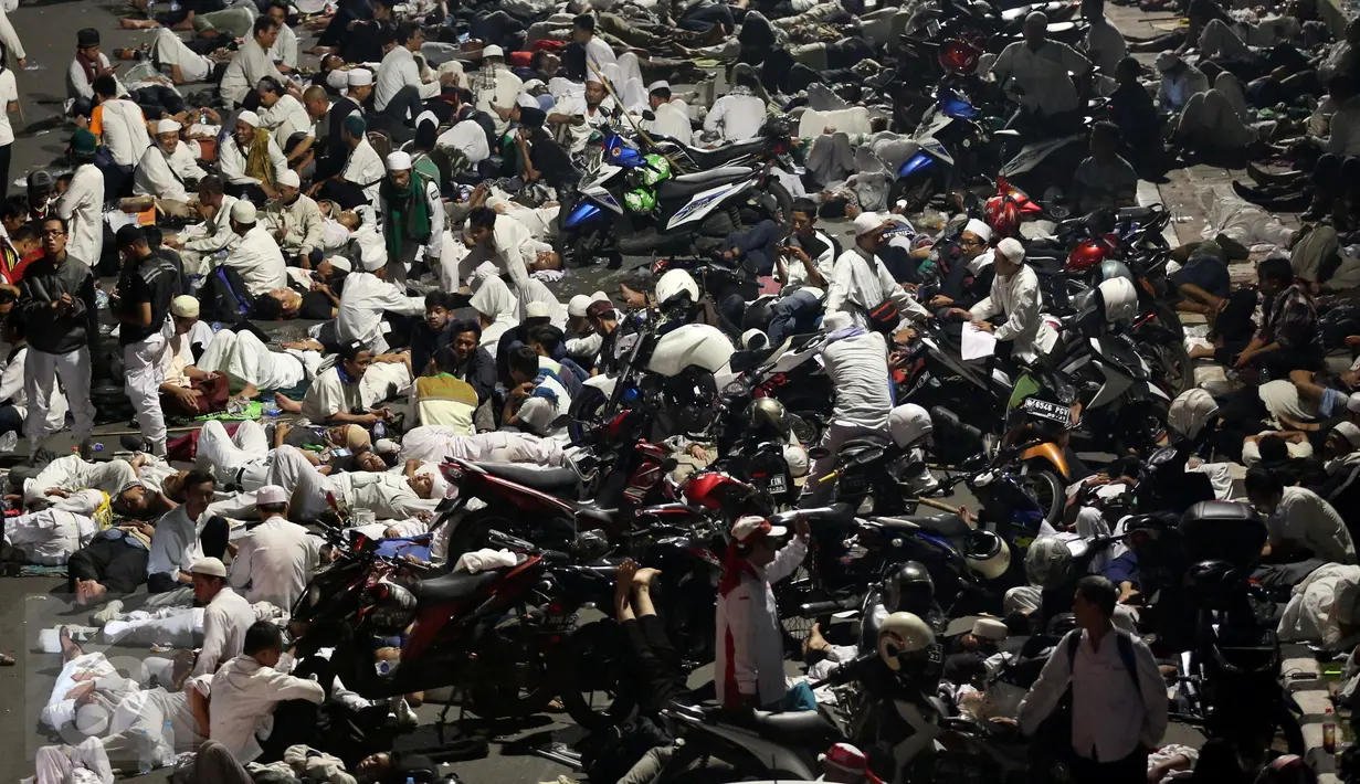 Massa peserta demo 4 November tidur di trotoar Jalan Gatot Subroto, Jakarta atau tepat di depan Gedung MPR/DPR RI, Jumat (4/11). Mereka terpaksa menginap di jalan depan Gedung DPR lantaran tak diizinkan masuk ke komplek parlemen (Liputan6.com/Johan Tallo)