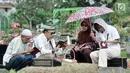 Umat muslim berdoa di dekat pusara keluarganya saat ziarah di TPU Karet Bivak, Jakarta, Minggu (25/6). Hari pertama Lebaran, sejumlah warga memadati TPU untuk melangsungkan tradisi ziarah usai salat Idul Fitri. (Liputan6.com/Yoppy Renato)