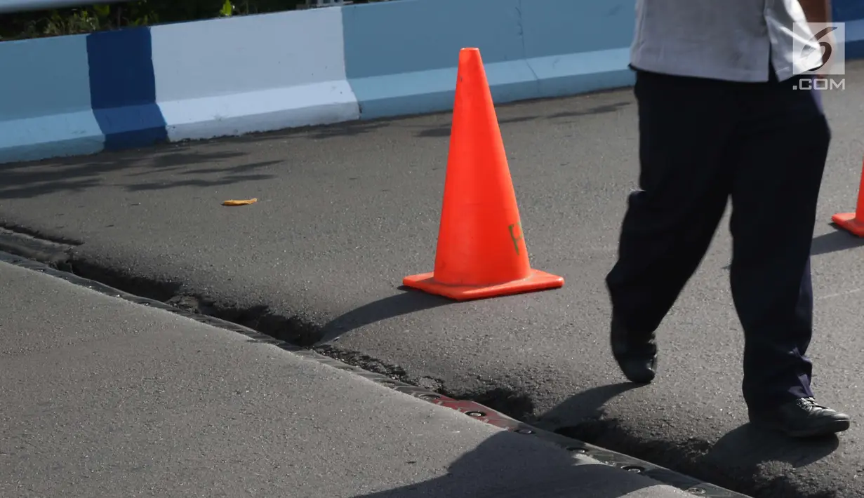 Petugas Dishub DKI Jakarta mengecek kondisi salah satu ruas jalan layang yang retak di kawasan Kemayoran, Jakarta, Kamis (3/1). Akibat retakan ini, para pengendara harus lebih berhati-hati saat melintas. (Liputan6.com/Helmi Fithriansyah)