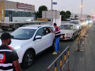 Petugas medis mendata orang-orang yang antre memasuki sebuah stasiun pengujian lantatur (drive thru) baru untuk COVID-19 di Kegubernuran Mubarak Al-Kabeer, Kuwait, 20 September 2020. Kuwait membuka stasiun pengujian PCR lantatur baru untuk memperluas kapasitas pengujian COVID-19. (Xinhua/Asad)