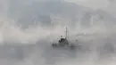 Sebuah kapal saat melintasi sepanjang Sungai Yenisei ditengah kabut dingin di Taiga luar kota Siberia Krasnoyarsk, Rusia, Selasa (17/11/2015). Suhu udara minus hingga 20 derajat Celsius. (REUTERS/Ilya Naymushin)